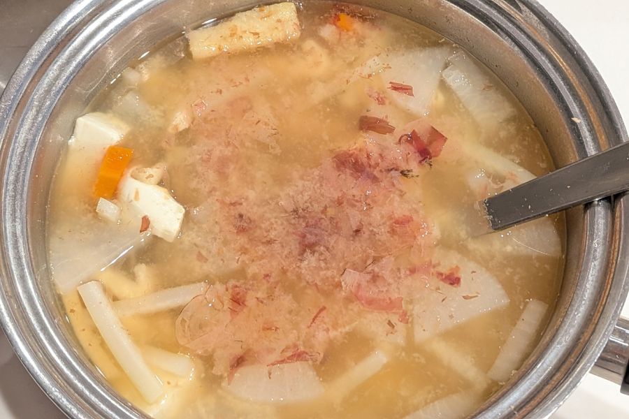 完成したお味噌汁に鰹節を加え仕上げの風味付けをしているところ