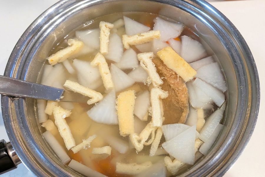 お玉ですくった味噌を鍋に沈めて余熱で緩める様子
